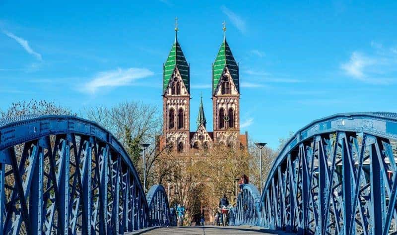 a steel bridge that leads to a church in Freiburg Germany