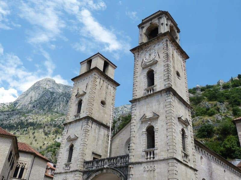 The tower of the Kotor cathedral with Kotor Castle in the back ground