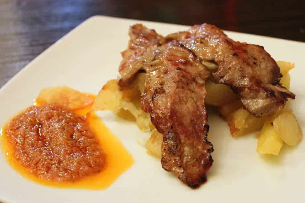 small meat and potatoes tapas with a dipping sauce served in Sevilla