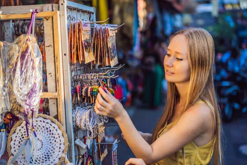 A young lady shopping in Bali for local goods at a market