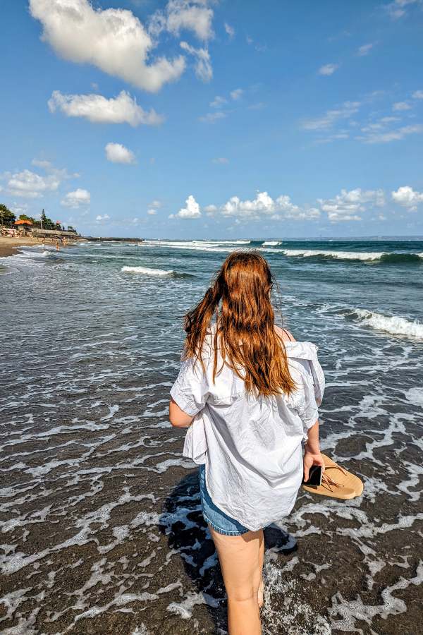 a teenage girl walking along canggu beach in Bali