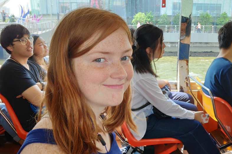a teenage girl on a scenic waterways boat tour, surrounded by cultural wonders and vibrant city life