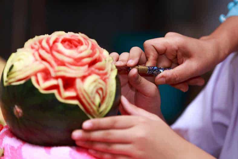 a person learning how to carve fruit in bangkok