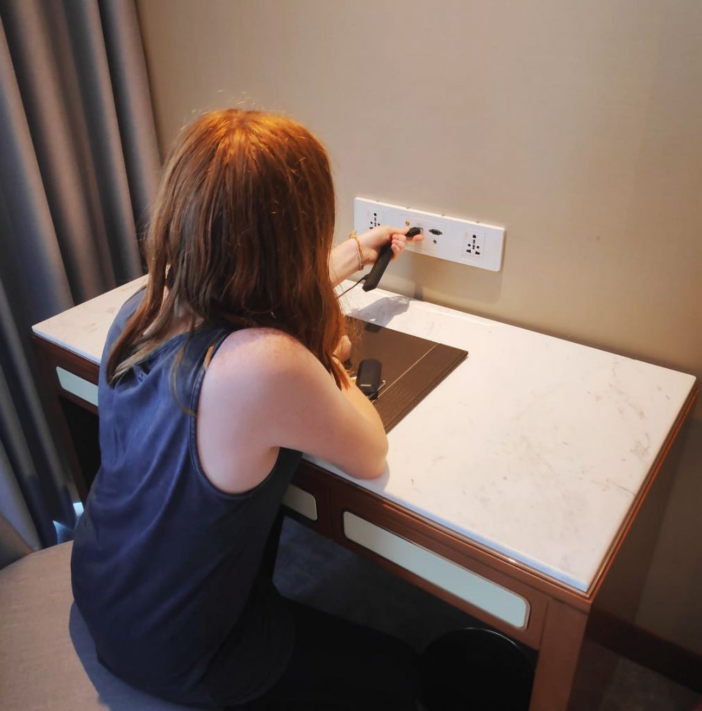 teenage girl sitting at the desk with charging points at the best hanoi hotel