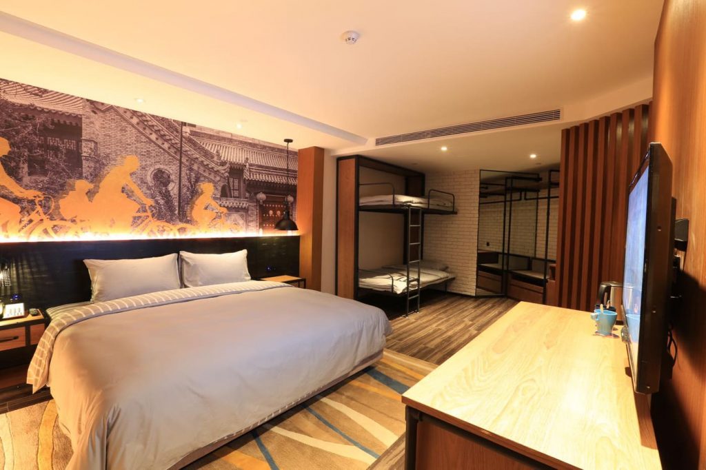 large bedroom witth queen size bed and bunks for families in China