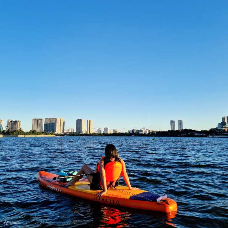 a teenager sitting on a paddle board in Ho Chi Minh City