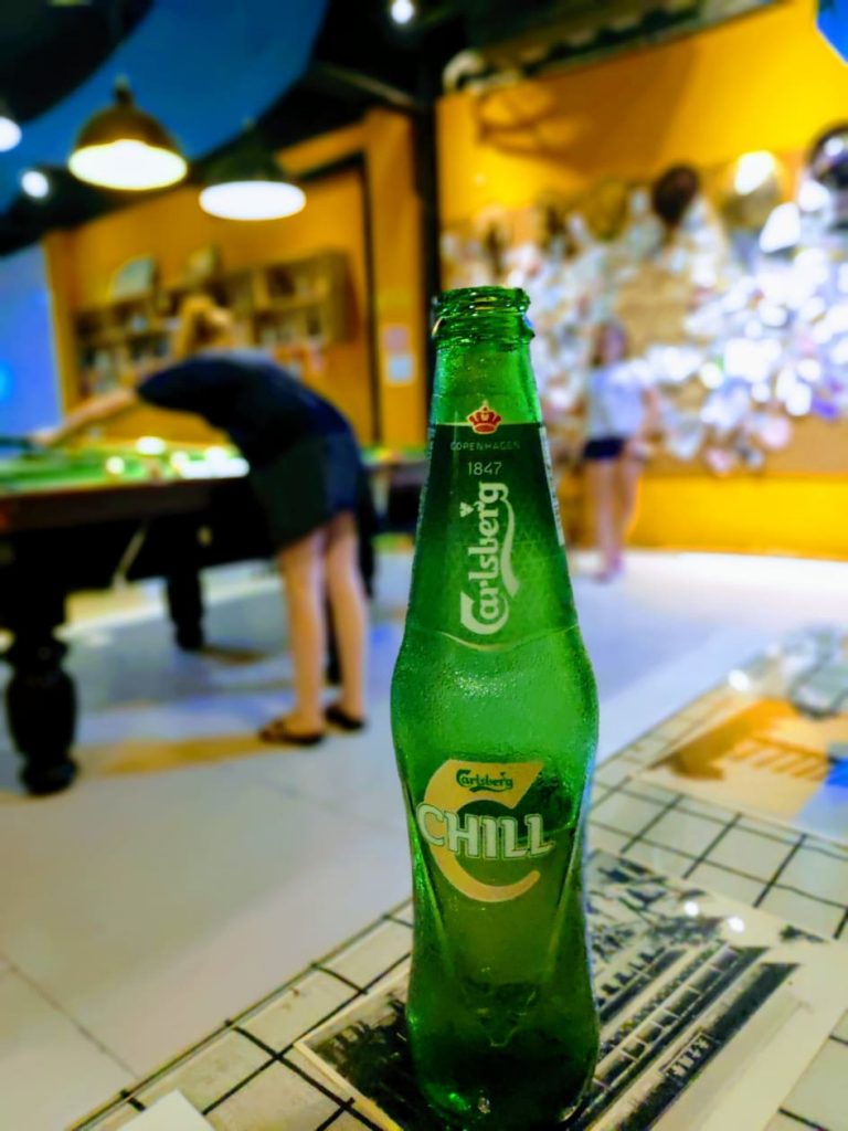 Having a drink at a Xian, China hostel while teenagers play pool in the background