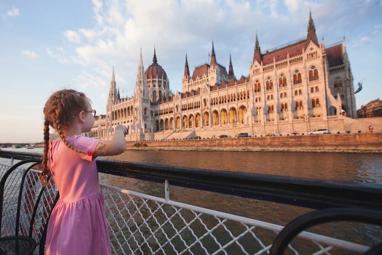 A young kid on a cruise down the Danube going past the parliment buiding