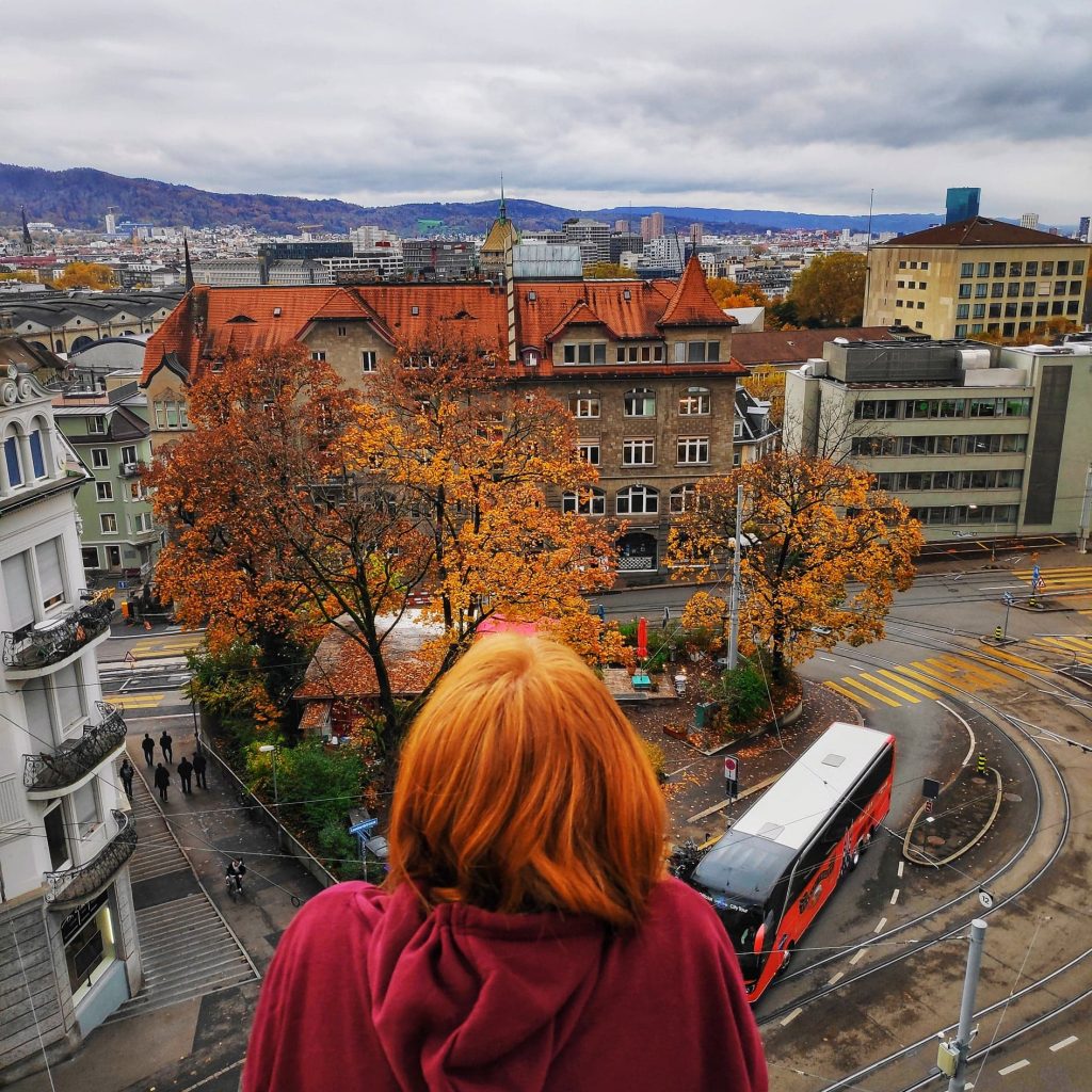 a redheaded girl looking off the balcony over Zurich from the Leoneck Hotel