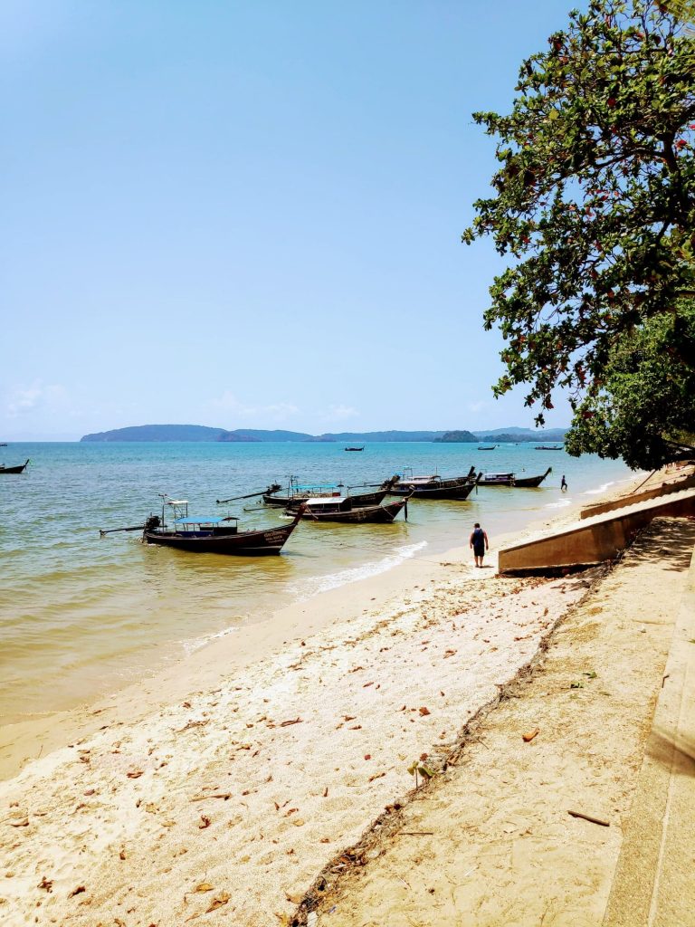 Kids playing in the sand and splash in the shallow water at Ao Nang Beach in Krabi