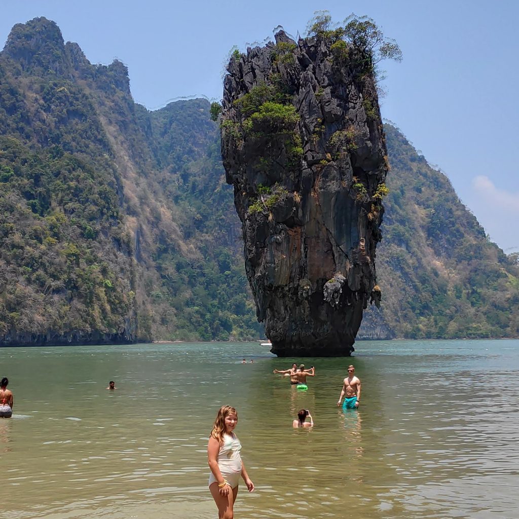 a young girl standing in front of the James Bond Island in Thailand