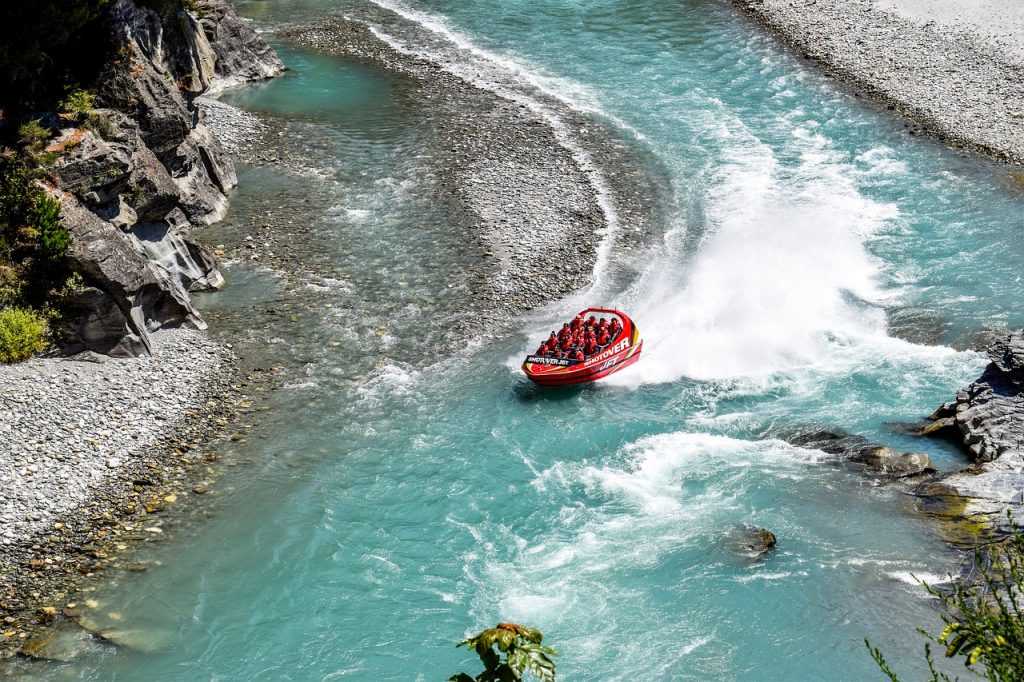a jet boat going down a river near Queenstown New Zealand