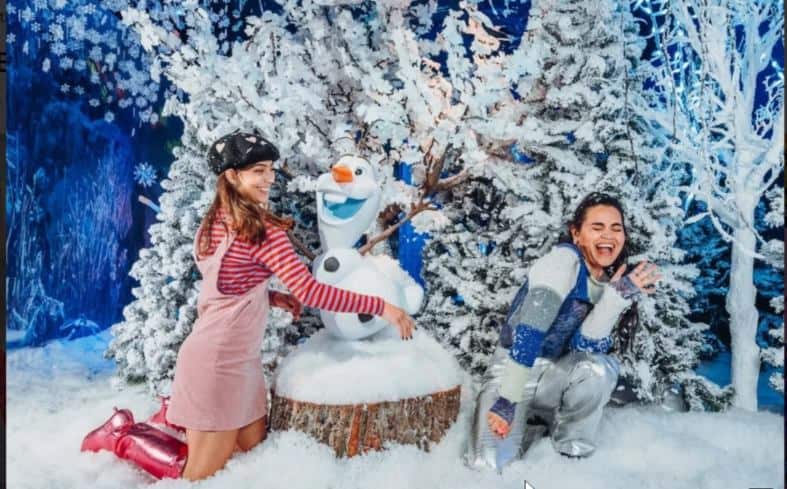 2 teenage girls exploring an inreactive exhibit at Wondr in Amsterdam playing in fake snow