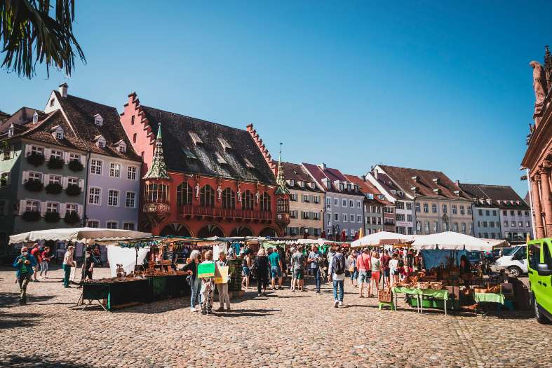 people out shopping at the Freiburg market that surrounds the Munster