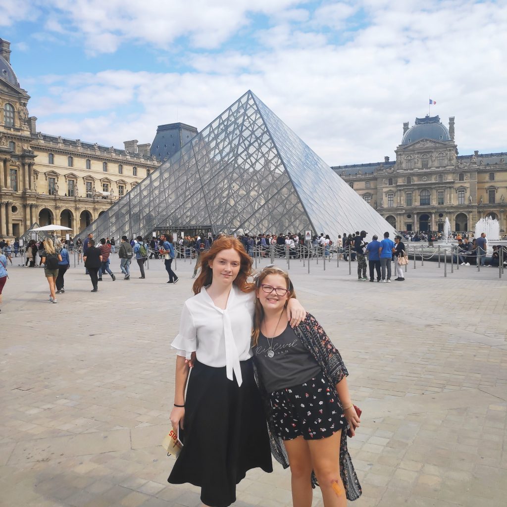 2 teens in Paris at the Louvre. Visiting the Lourve is one of the most educational things to do in Paris with teenagers
