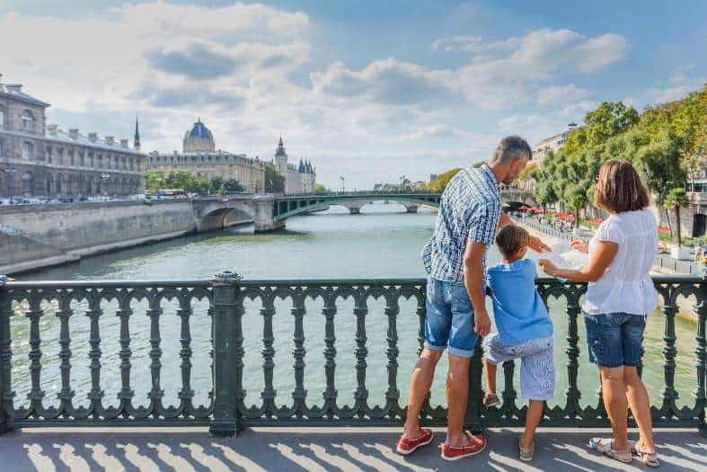 A family with a young kids looking at Seine River in Paris