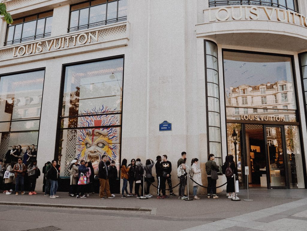 locals and tourists lining up at a Louis Vuitton store