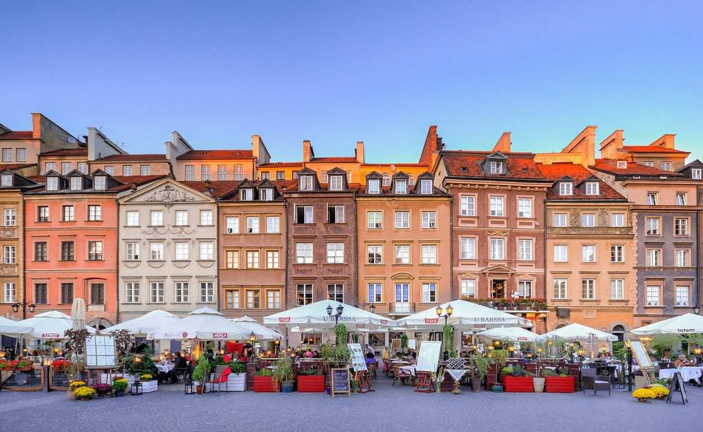market in Warsaw Old Town. A set of colouful buildings with tables out the front with umbrellas