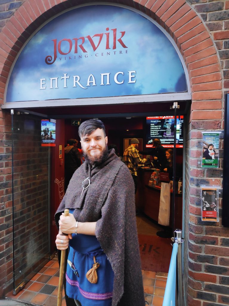 A worker in Viking costume out from of the Viking Museum in York