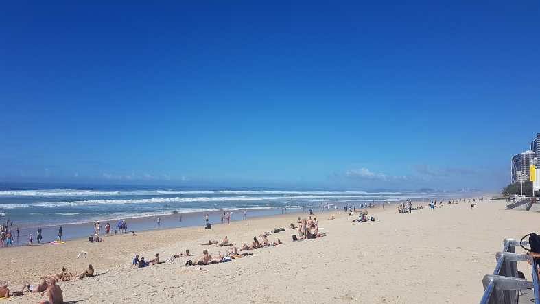 white sand blue skies and people sitting on the beach in Adelaide