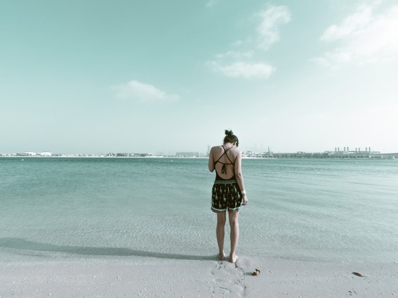 a young lady standing on the waters edge in Dubai