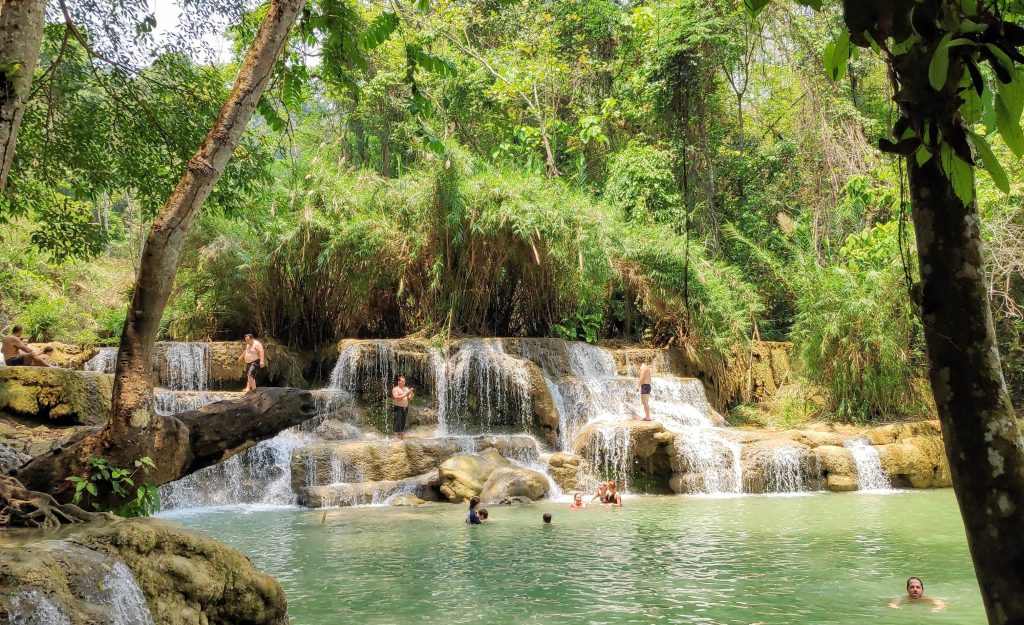 teenagers stand in awe at Kung Si Waterfall near Luang Prabang, Laos