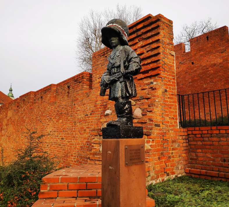 a statue in warsaw of a child armed fighter