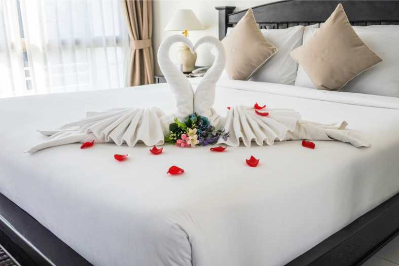 a bed in a hotel room look romantic with flowers on it