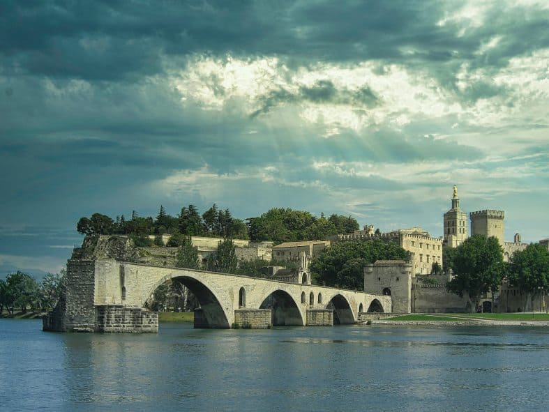 A ruined bridge with a medieval fortress in the background at Avignin in France