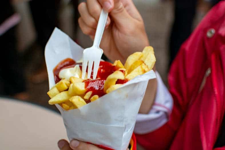 Belgium Fries in a cone topped with tomato sauce