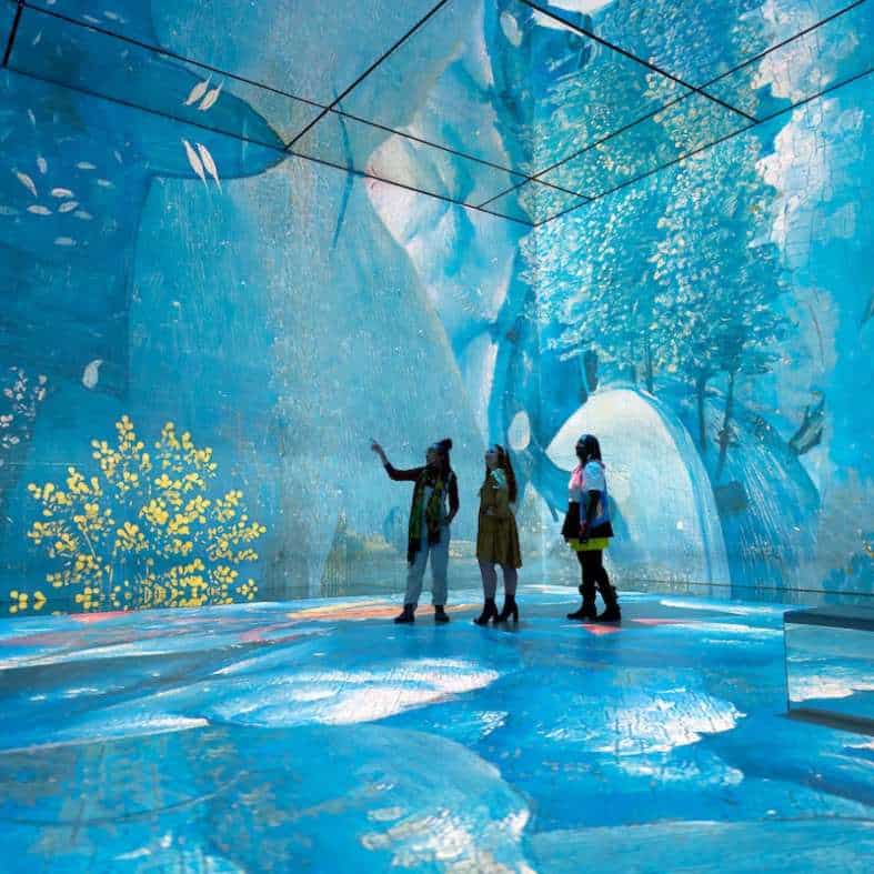 teens immersed in interactive art in London at Frameless in a blue room