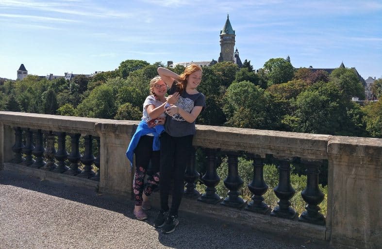 Two teen girls having fun on a bridge in Luxembourg City on their best vacations for families with teenagers