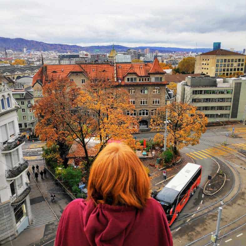 a teenage girl on a balcony looking over Zurich. vacations with teens don't always need to be full of activities