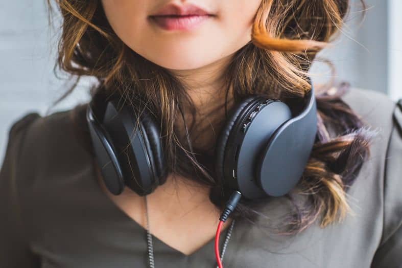 a young adult female traveller wearing headphones