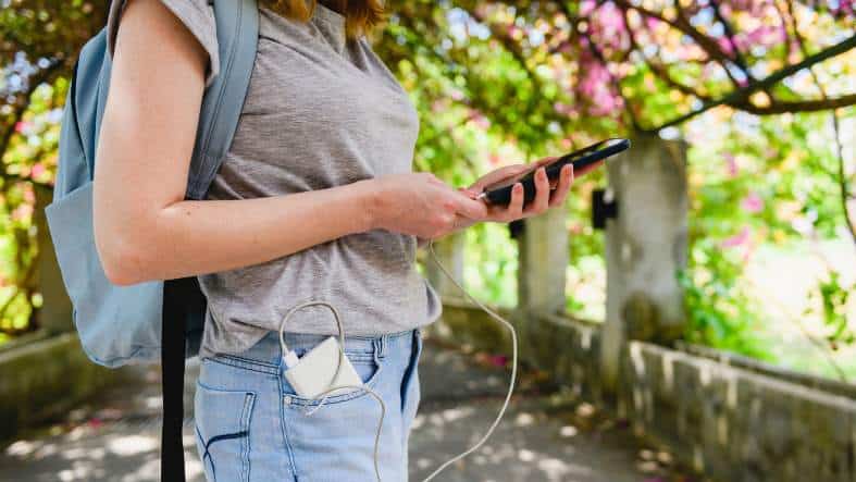 a teenager travelling charging her phone