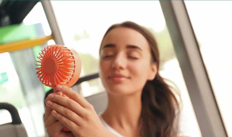 a teenage using a portable fan