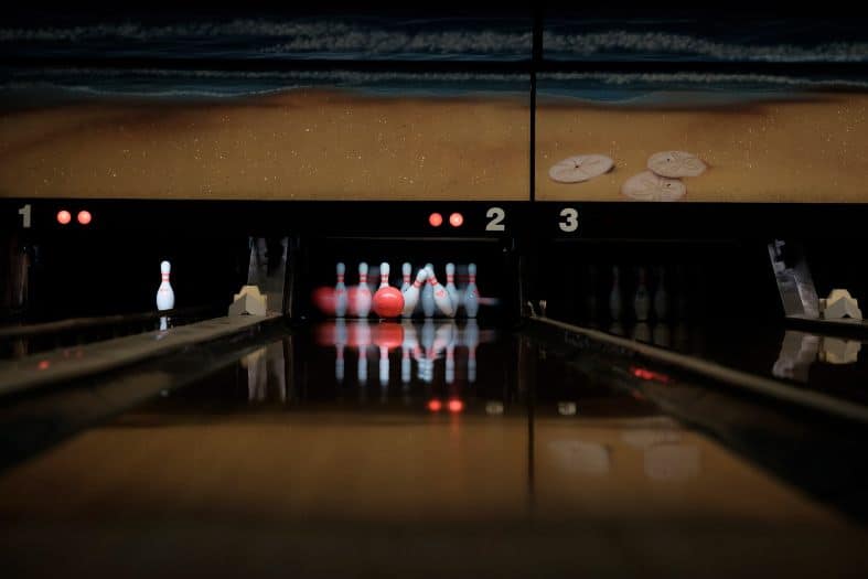a vibrant bowling alley with teenagers enjoying a game