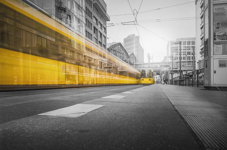 A yellow tram travelling through Alexanderplatz in Berlin