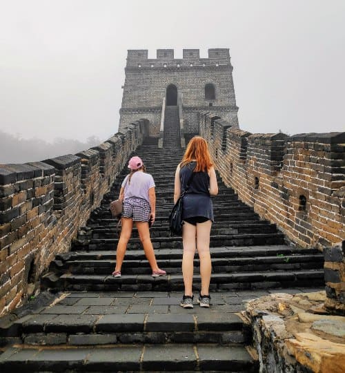 2 teens standing on the great wall