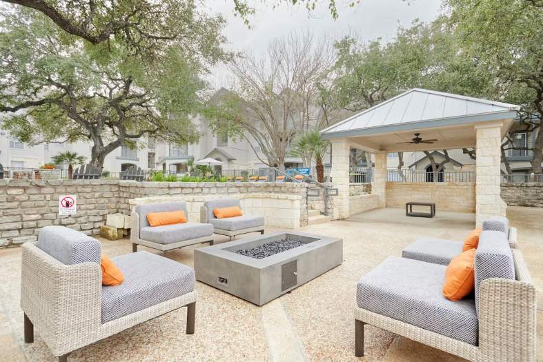 An outdoor area featuring cushioned chairs and a fire pit in San Antonio
