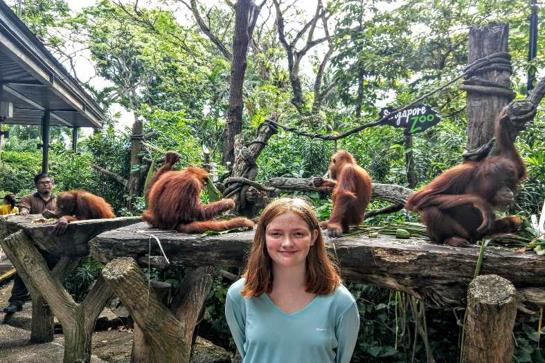 A teenage girl standing in front of the South East Asia orangutans