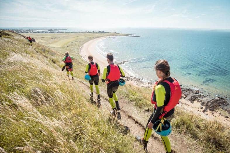 Teenagers walking along a trail at a beach near Edinburgh