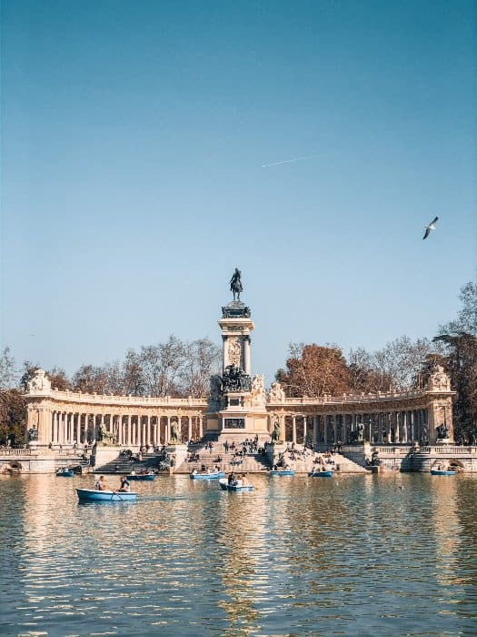 Lake and statue with paddle boats at Retiro Park in Madrd