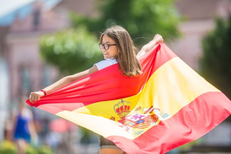a teen in Madrid having fun holding a soanish flag