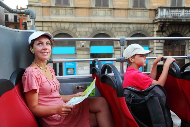 a mother and son sitting on the hop on hop off bus in Rome
