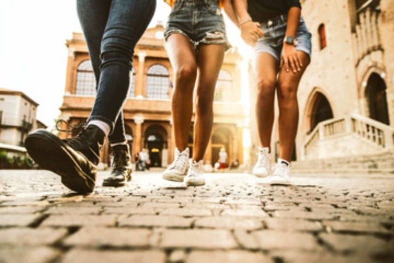 3 teenagers walking on the cobbled streets of Rome