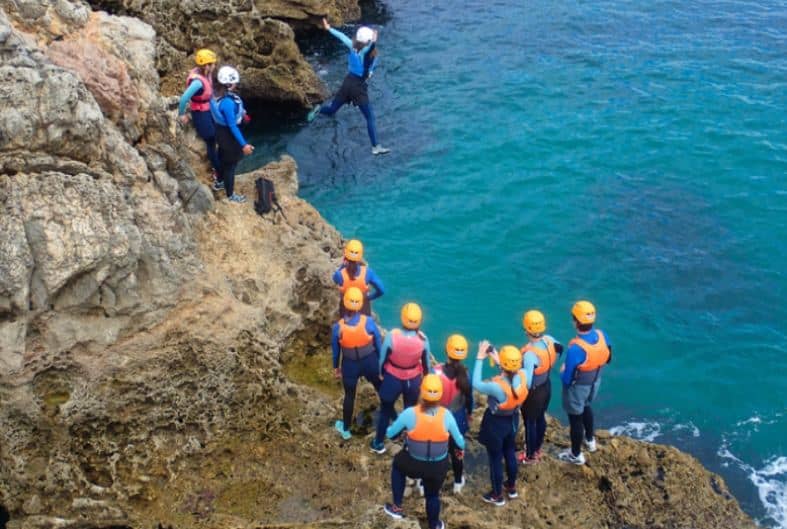 People on holiday in Portugal participating in coasteering.