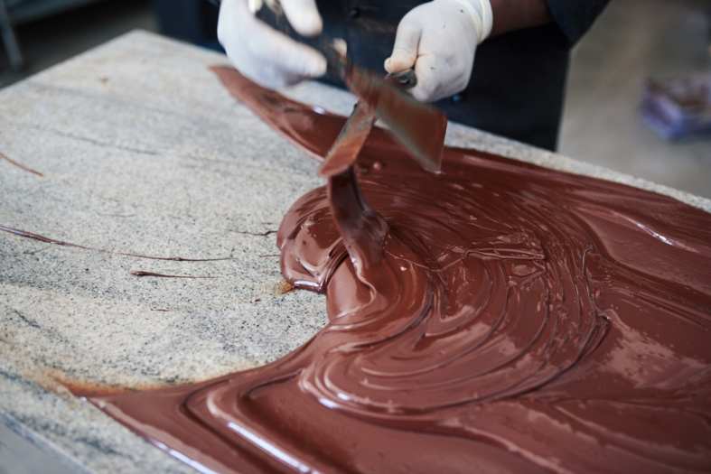 a person spreading chocolate on a table