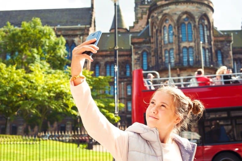 Teenager capturing memorable moments of their sightseeing adventure in Glasgow
