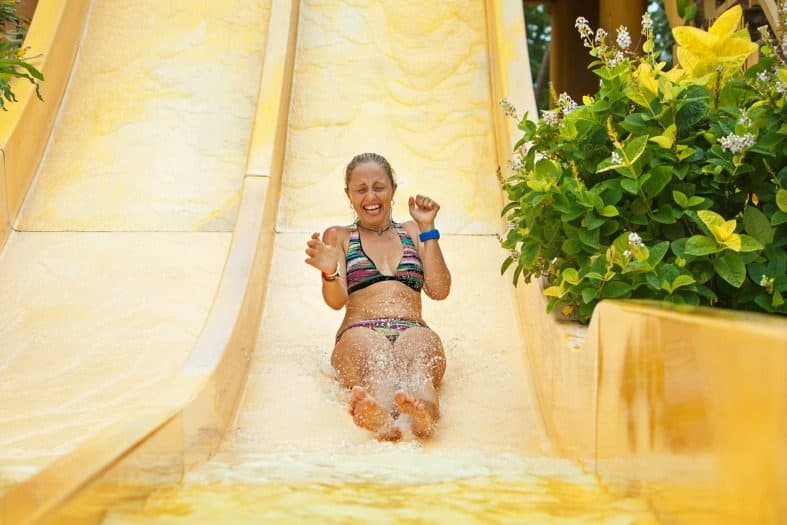 a teenager girl in Istanbul going down a slide of water.